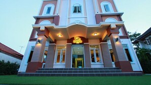 A multi-story building with a central entrance, large windows, and a sign that reads "Excella". - Excella Hotel (Ubon Ratchathani)