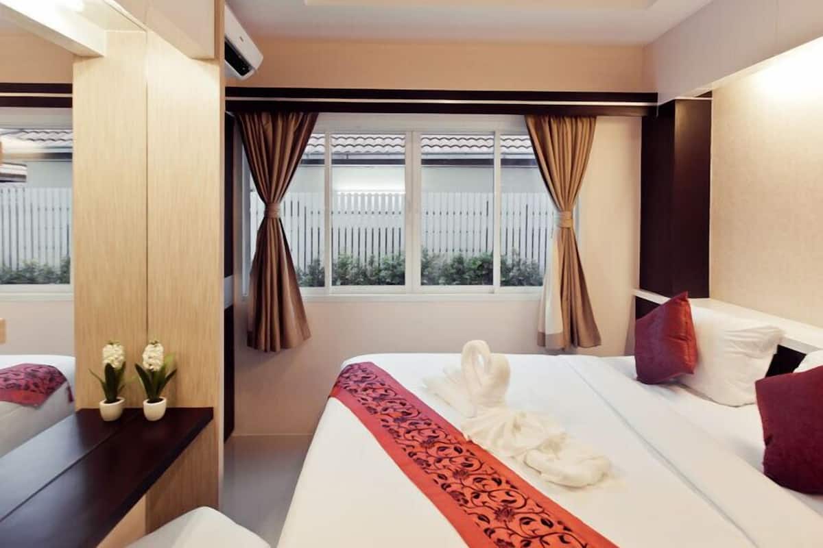 Una habitación de hotel con cama, escritorio y ventana con cortinas.