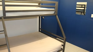 Uma cama beliche com colchão e estrutura metálica.