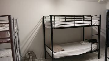 A bunk bed room with a fan and a ladder.