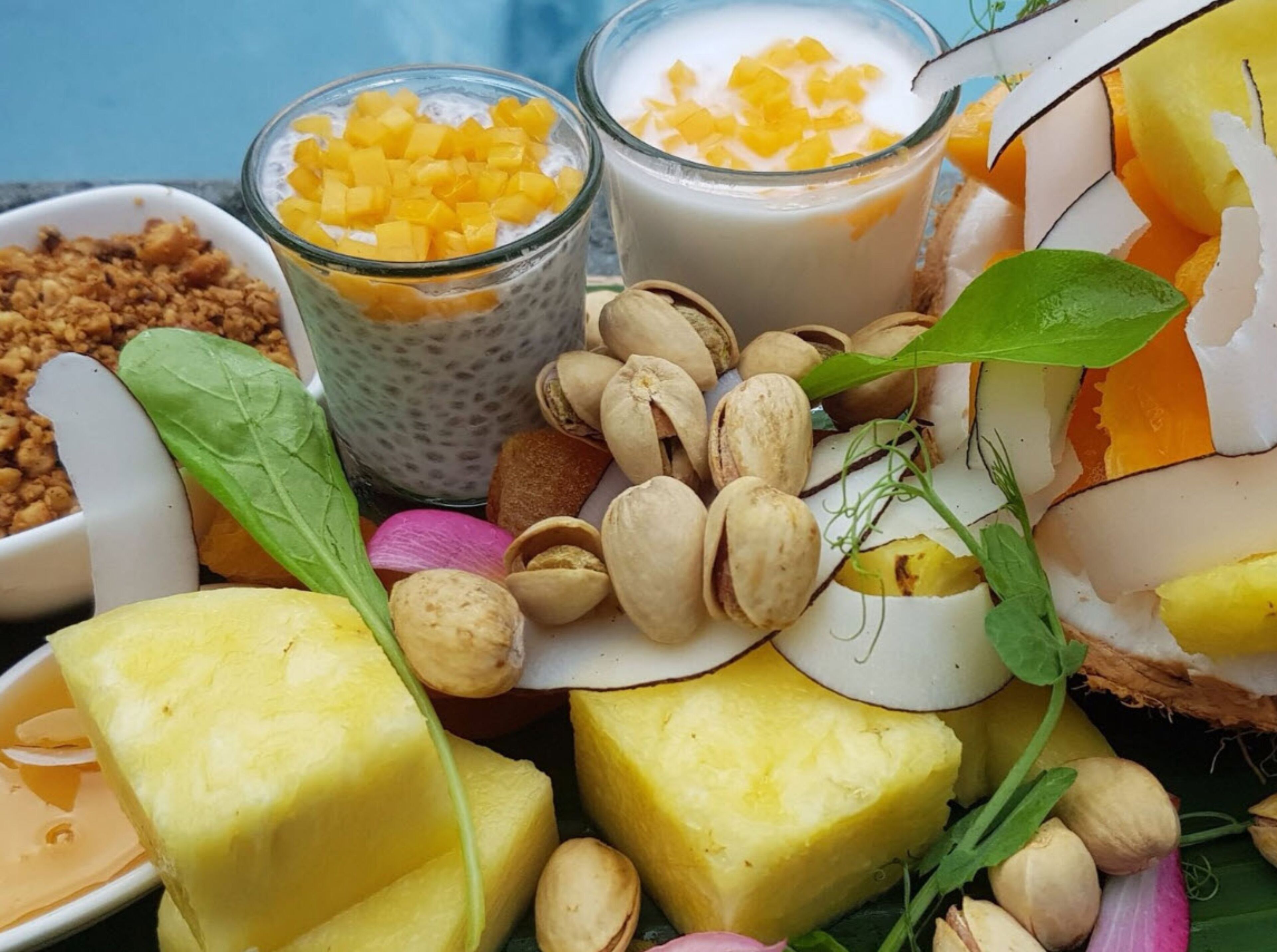 A variety of food items including mango chunks, coconut, and pistachios.