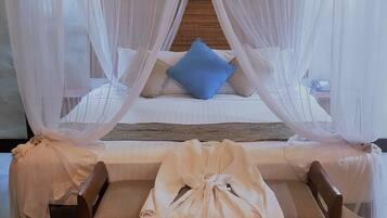 A bed with a canopy, pillows, and a bedside table.