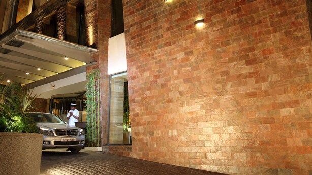 A hotel entrance with a brick facade and illuminated signage for 'VRISA HOTEL & BANQUET LOUNGE'. - Hotel Vrisa (Jaipur)