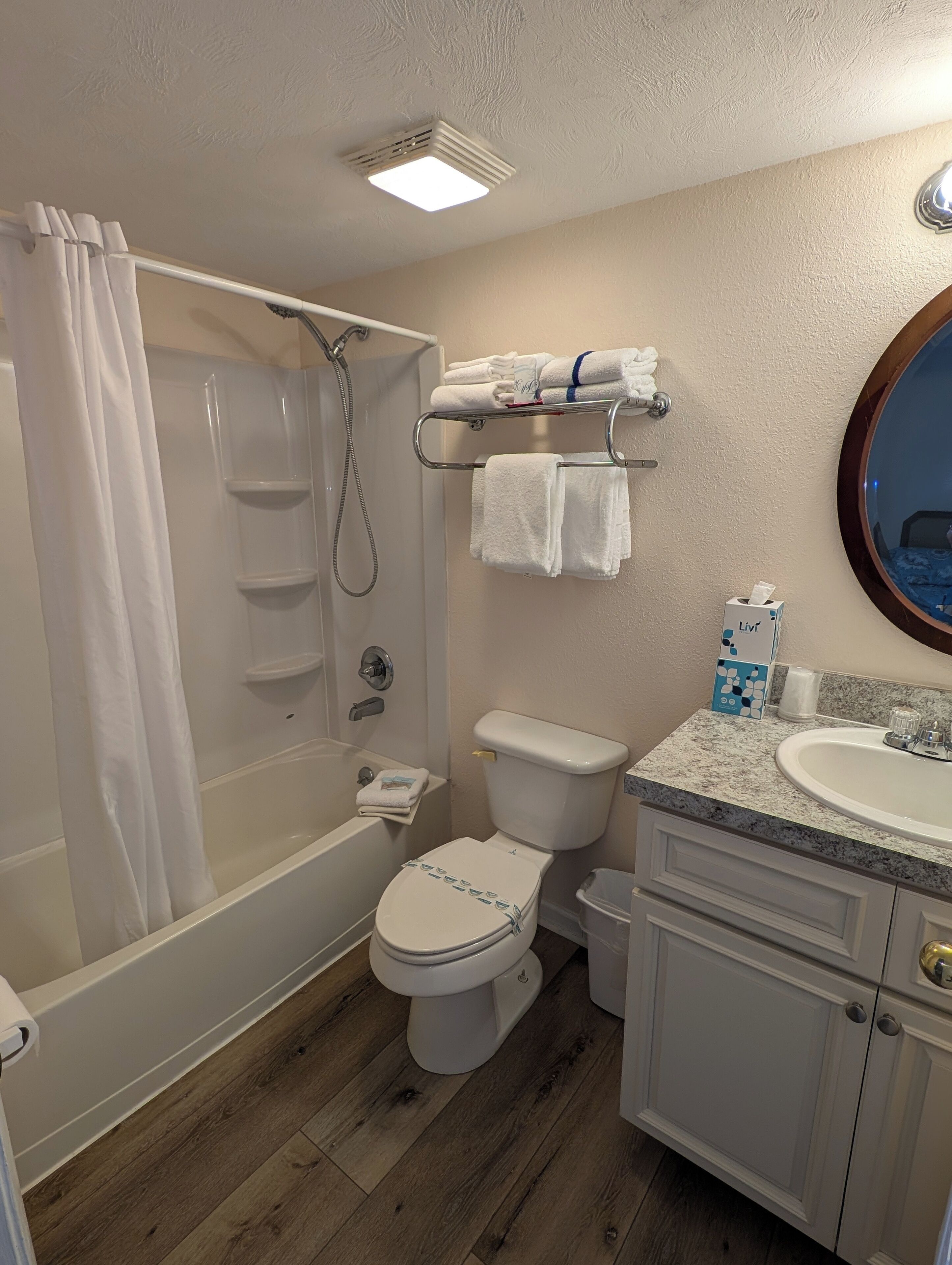 Un baño con ducha, inodoro, lavabo y toallero.