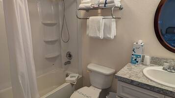 Un baño con ducha, inodoro, lavabo y toallero.