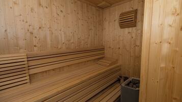 A sauna room with wooden benches and a ventilation system.