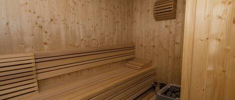 A sauna room with wooden benches and a ventilation system.