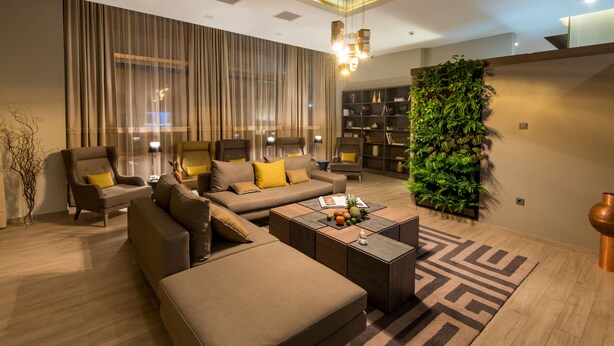 A modern living room with a sofa set, a coffee table, and a bookshelf.