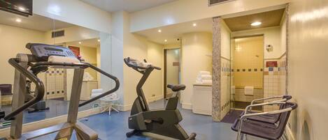 A gym with treadmills, elliptical machines, and a stationary bike.