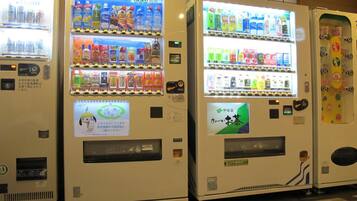 A row of vending machines with various beverages and snacks.