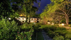 Una casa de dos pisos con un jardín cuidado y un sendero de madera que lleva a la entrada.