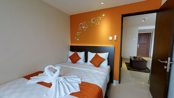 A hotel room with a bed, a wall art piece, and a door leading to another room. - The Gloria Suites Jakarta (Jakarta)