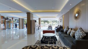 A spacious lobby with a modern design, featuring a sofa set, a coffee table, and a patterned rug. - The Gloria Suites Jakarta (Jakarta)
