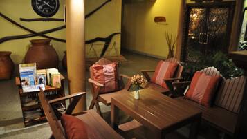 Un rincón acogedor con muebles de madera, una mesa y un reloj en la pared.