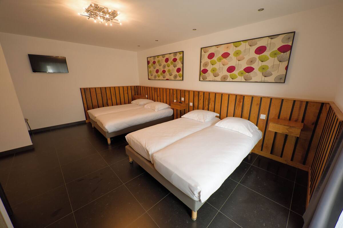 Een hotelkamer met twee bedden, een flatscreen televisie en kunstwerken aan de muur.