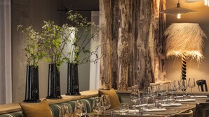 A restaurant with multiple tables set for dining, wooden chairs, and hanging pendant lights. - Le Relais Du Boisniard (Chanverrie)