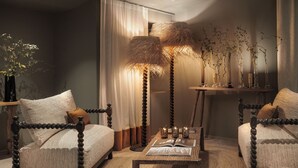 A bedroom with a four-poster bed, a bedside table with a book, a floor lamp, and a vase with plants. - Le Relais Du Boisniard (Chanverrie)