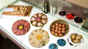 A buffet table with various food items including sliced bread, cheese, eggs, and pastries. - Park Hotel Sabina (Magliano Sabina)