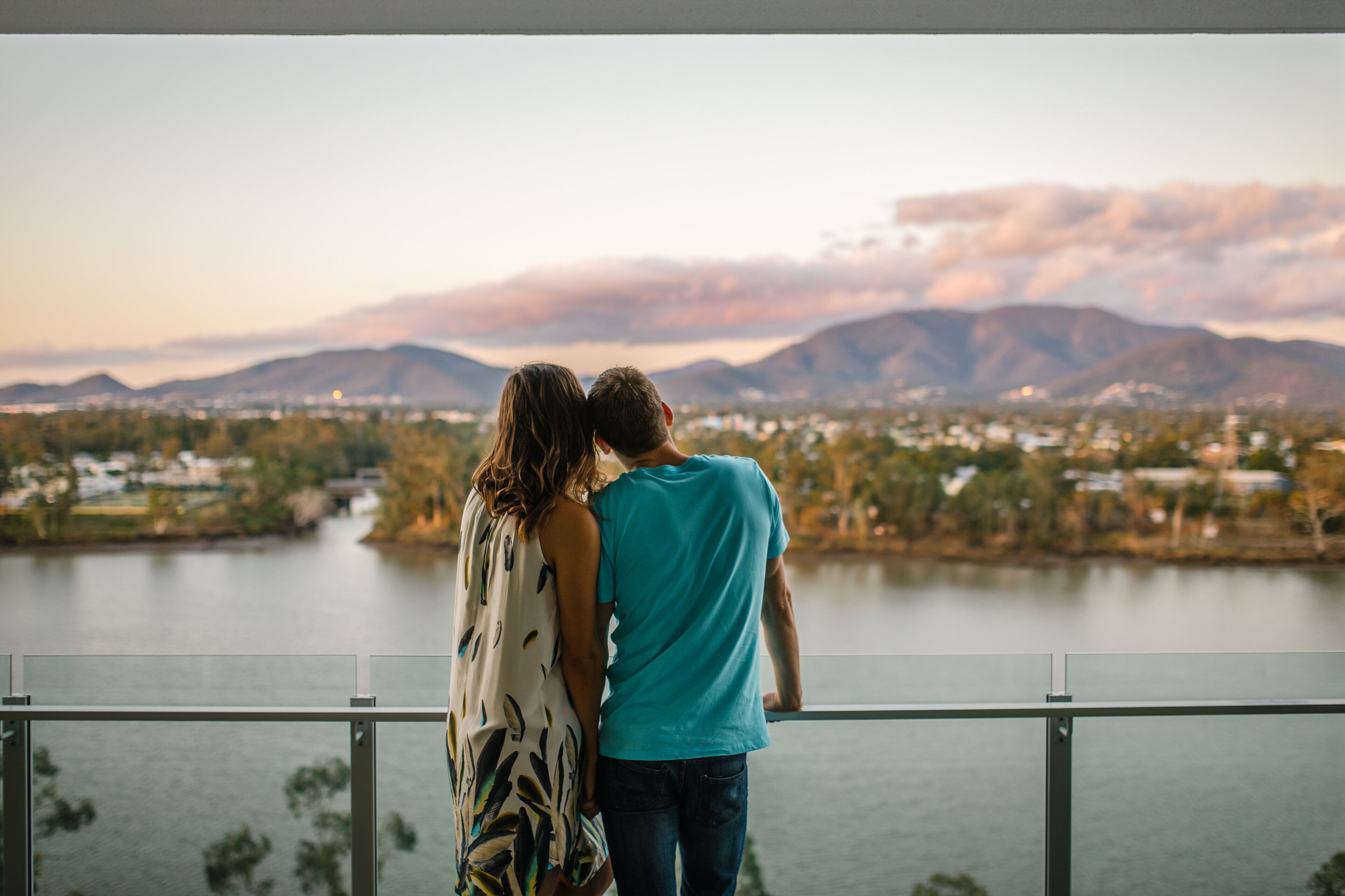 A couple overlooking a lake with mountains in the background.
