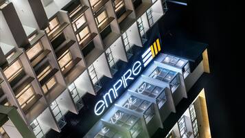 A modern building with a prominent 'Empire' sign, featuring a geometric facade and multiple balconies.