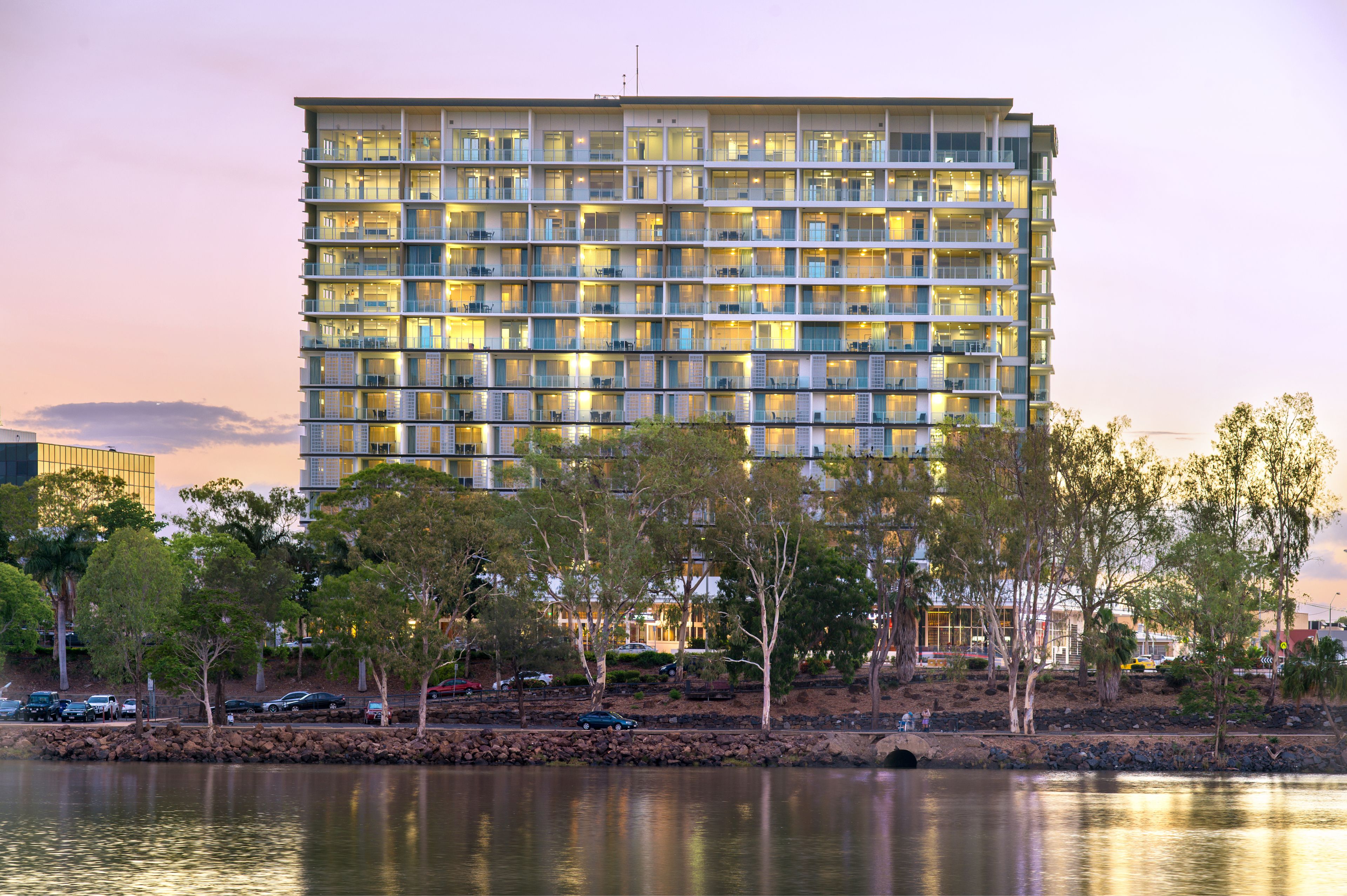 Ein mehrstöckiges Hotel mit Balkonen in der Nähe von Wasser.