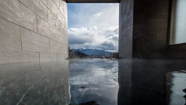 A reflective pool with a view of mountains and a cloudy sky. - Mizno Hotel (Fujikawaguchiko)