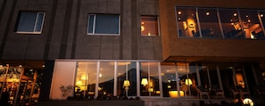 A modern building with large windows, a visible interior with seating and lighting, and a reflection of the sky. - Mizno Hotel (Fujikawaguchiko)