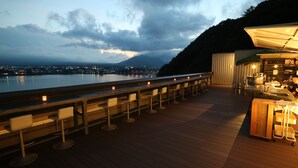 A bar area with a view of a body of water and a mountain in the distance. - Mizno Hotel (Fujikawaguchiko)
