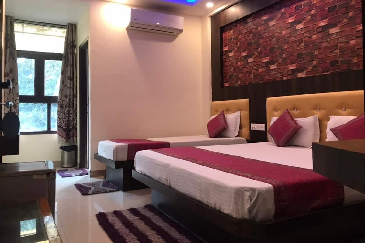A hotel room with two beds, a brick accent wall, and a modern ceiling design.