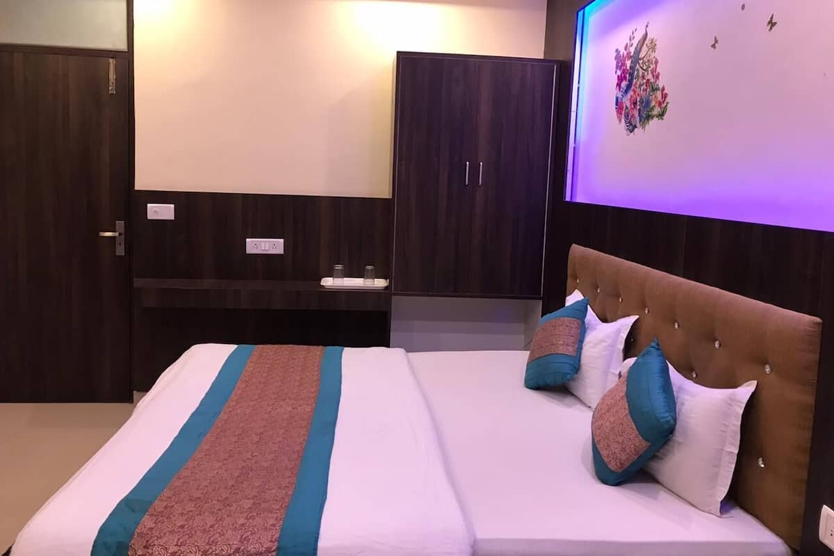 A bedroom with a bed, a wardrobe, and a wall-mounted TV.