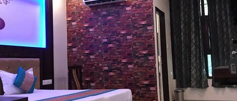 Un dormitorio moderno con pared de ladrillo, una cama con cabecera y un ventilador de techo.
