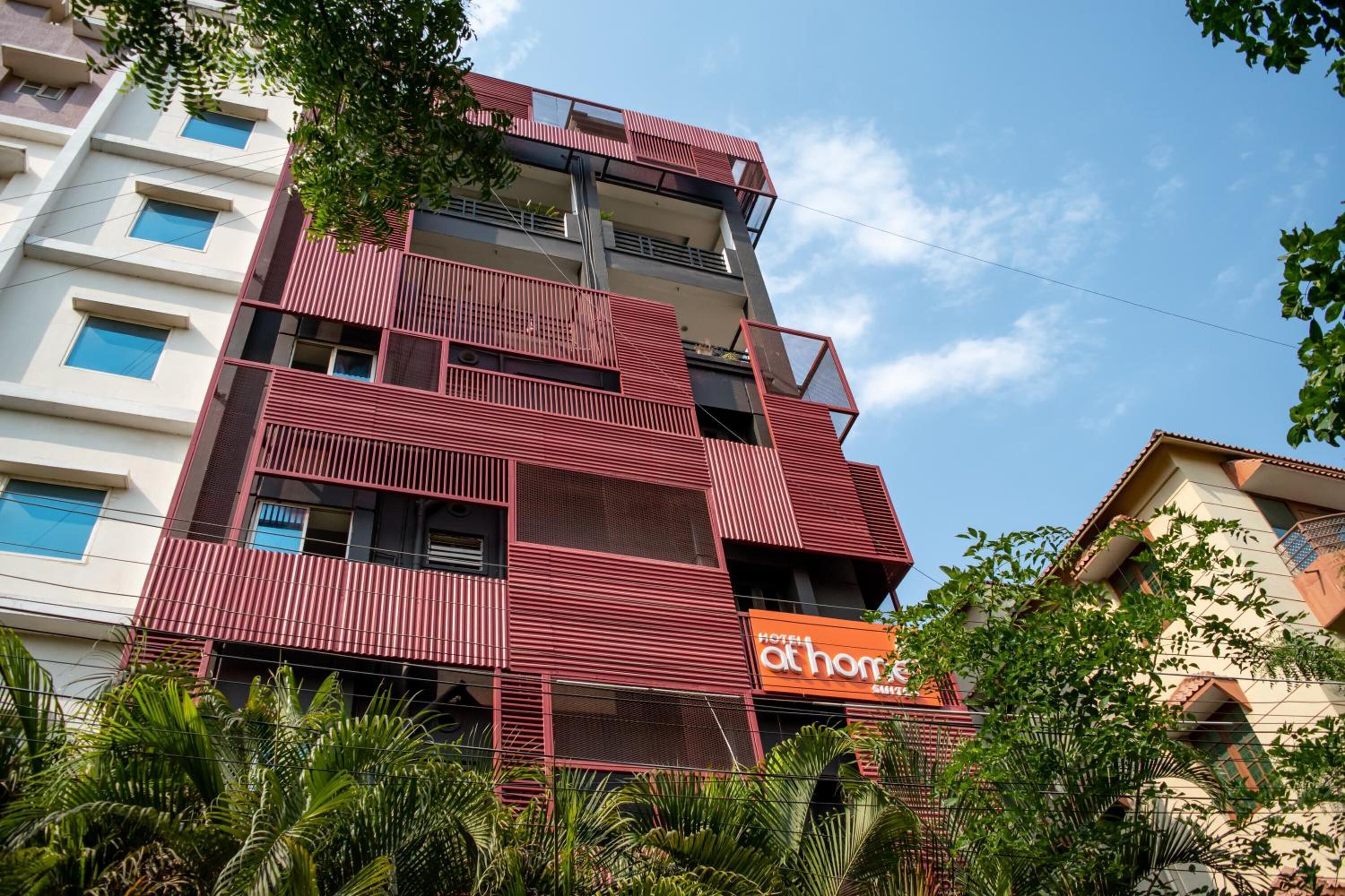 Un hotel de varios pisos con fachada roja y balcones.