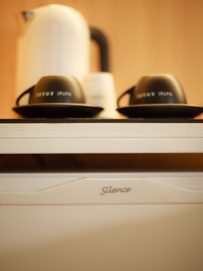 A kitchen area with a coffee maker and two cups on a counter. - Busan Amare Hotel (Busan)