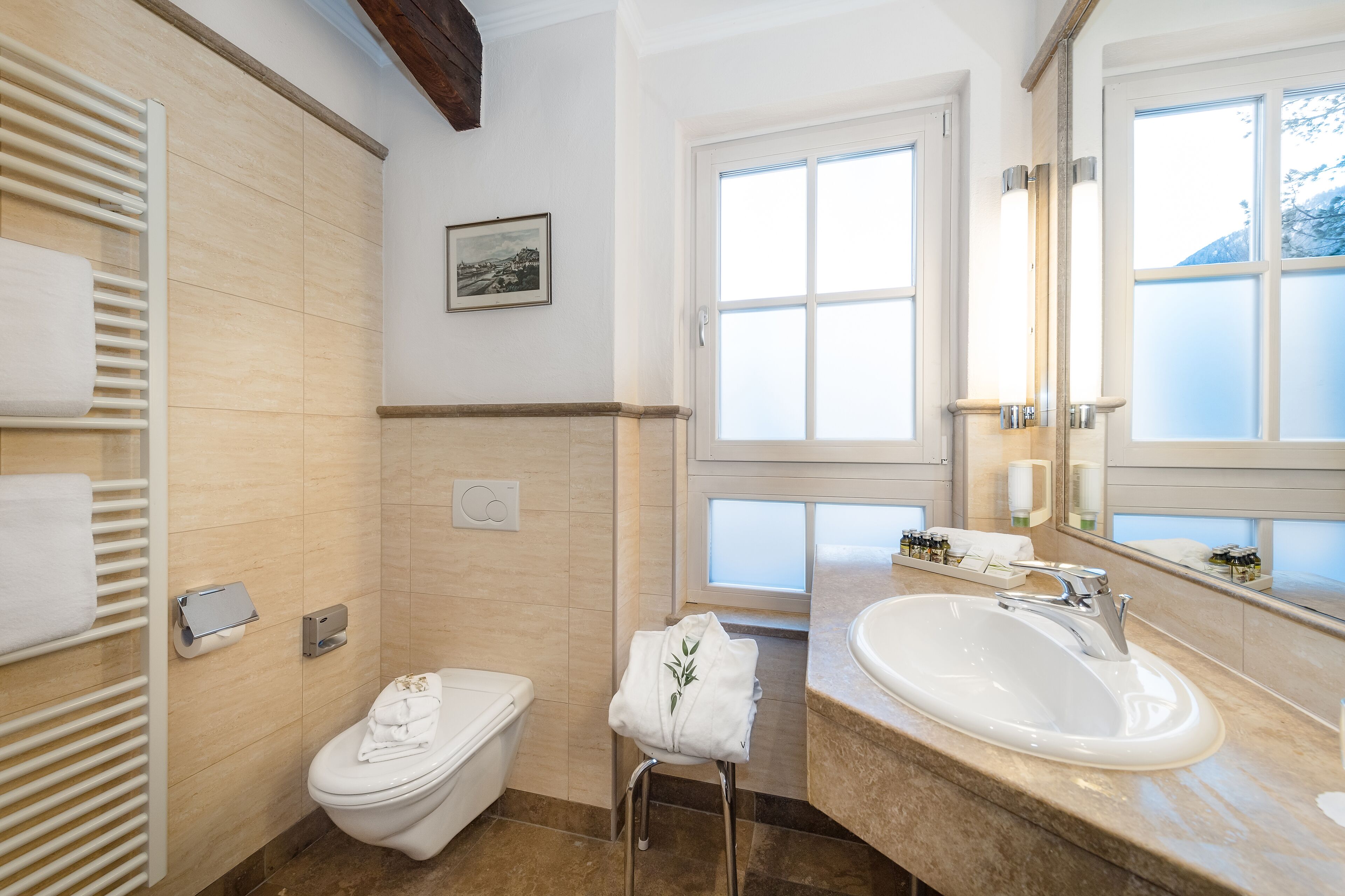 A modern bathroom with a toilet, a sink, and a towel rack.