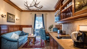 A cozy living room with a blue sofa, a wooden coffee table, and a chandelier. - Villa Orania (Bad Gastein)
