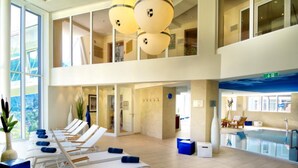 A spacious indoor area with sun loungers and a pool. - Villa Orania (Bad Gastein)