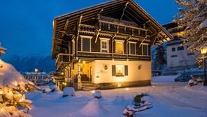A traditional wooden building with a balcony, snow-covered surroundings, and a sign indicating it is Villa Orania. - Villa Orania (Bad Gastein)