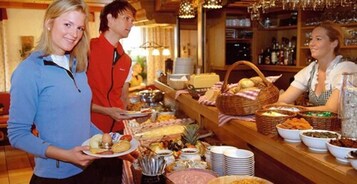 Montaje de bufé con diferentes alimentos y una zona de bar.