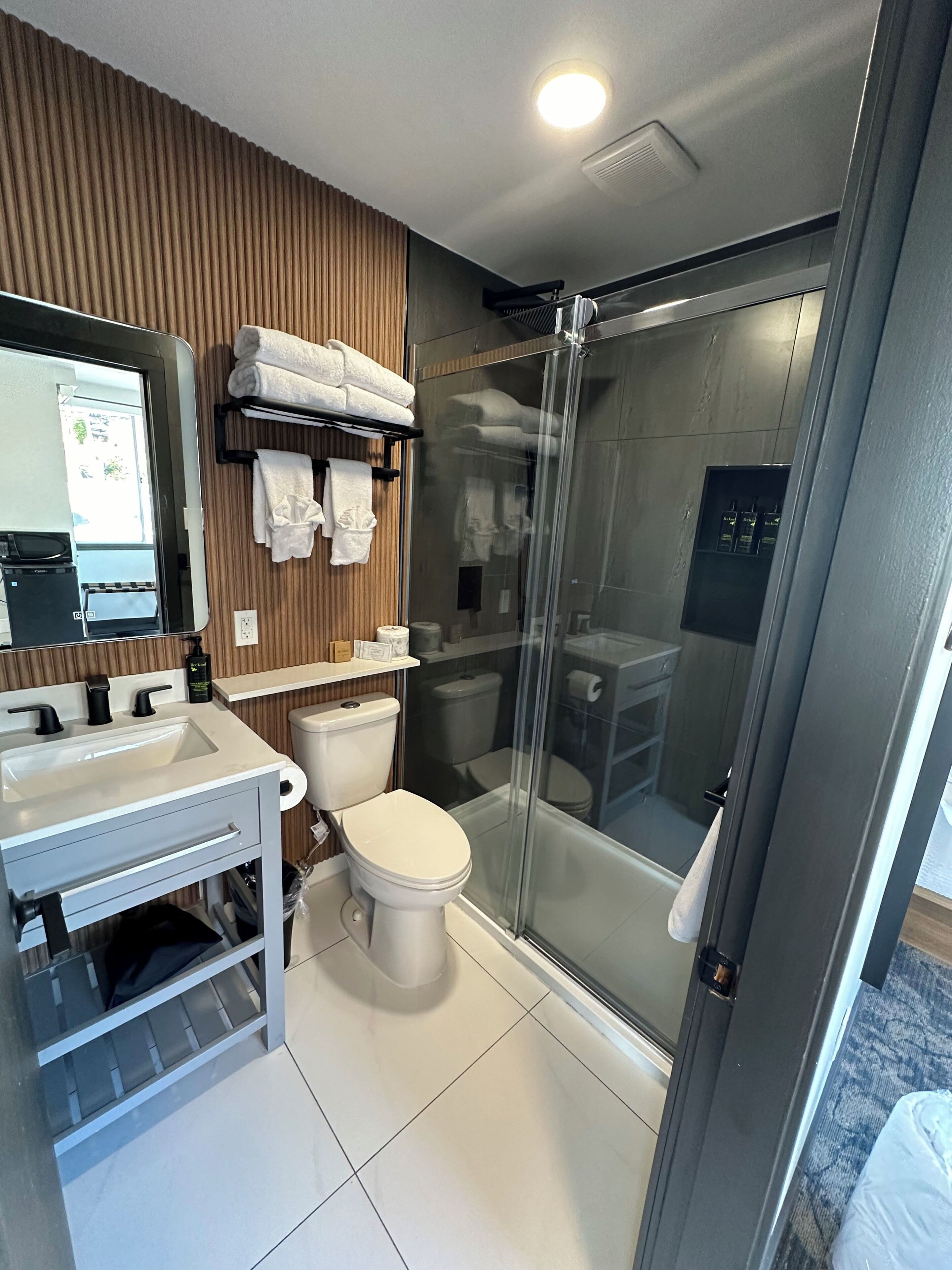 A modern bathroom with a shower, toilet, and sink.