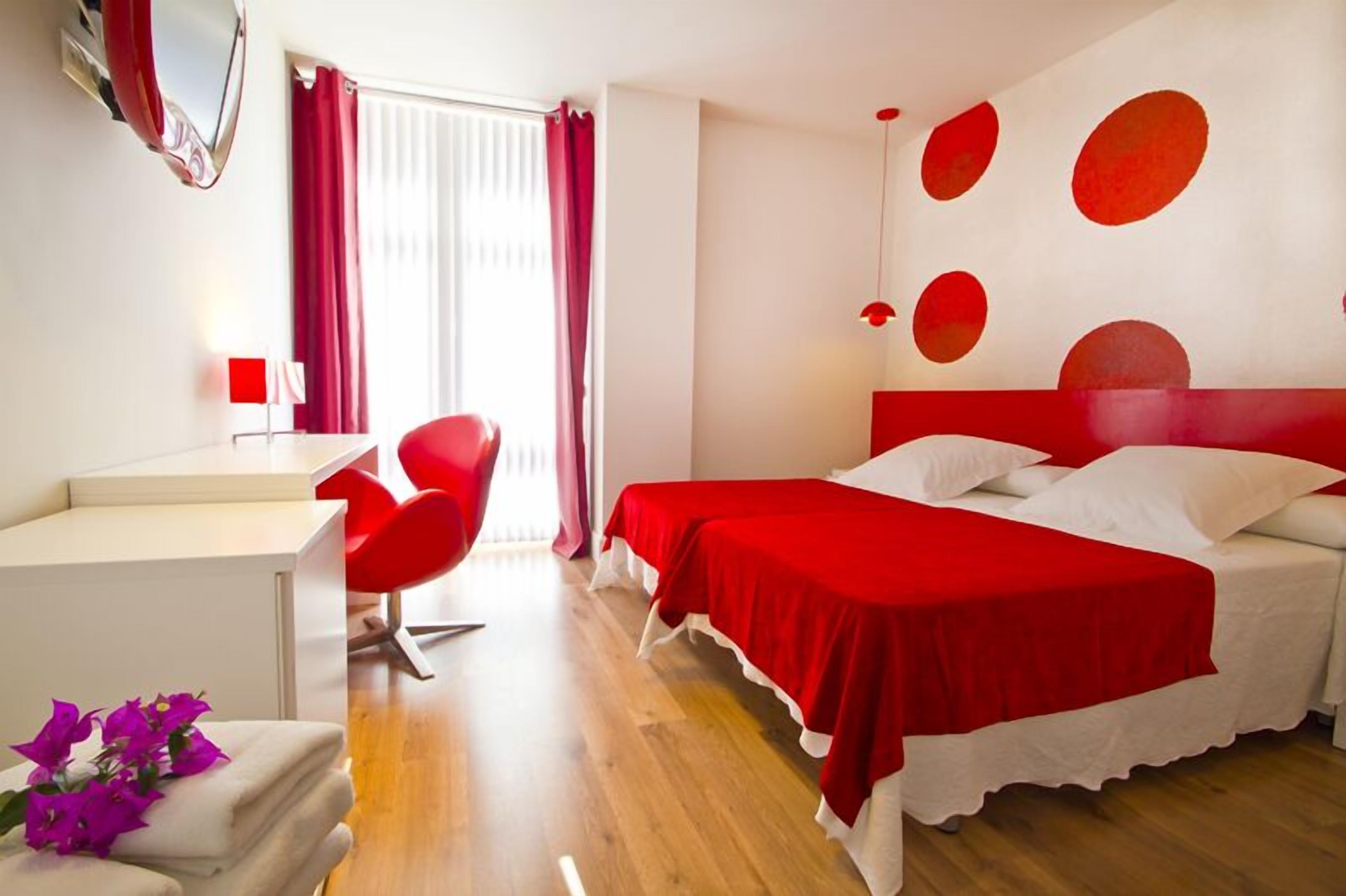 Une chambre d’hôtel avec un lit, un bureau et une chaise.