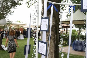 Un árbol adornado con cintas verticales y decoraciones colgantes, probablemente para un evento.