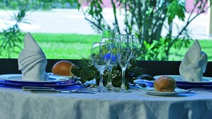 A table set for a meal with plates, glasses, and a bread roll. - La Bruca Resort (Scalea)