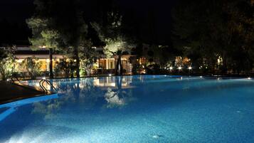 Una piscina al aire libre de temporada, sombrillas