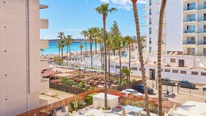 A pool area with lounge chairs, umbrellas, and palm trees. - Universal Hotel Bikini (Sant Llorenc des Cardassar)