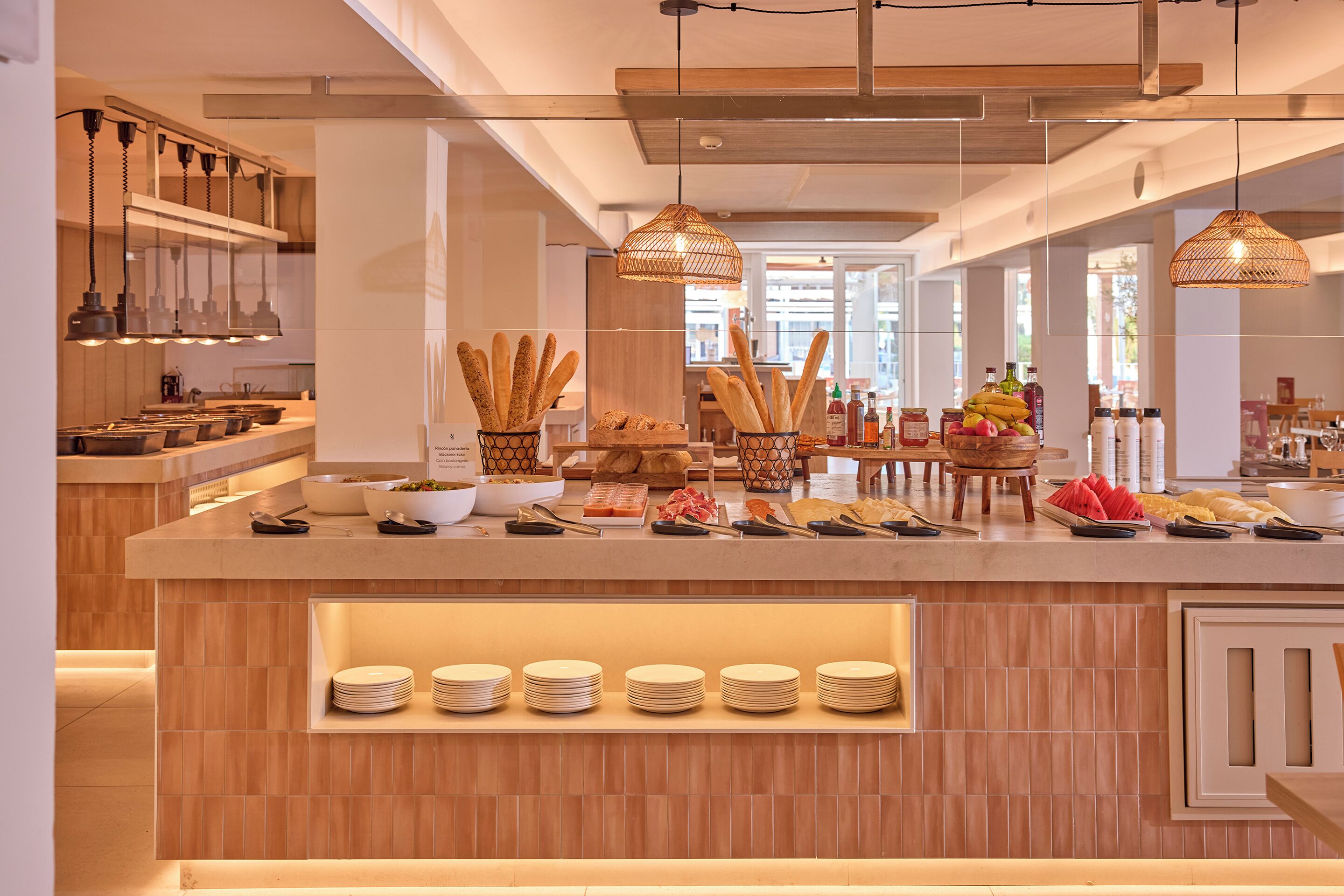 Een buffetgedeelte met diverse soorten eten, zoals brood, fruit en toevoegingen.