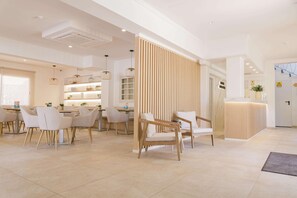 Um hall de hotel moderno com balcão de recepção, área de estar e divisória de madeira.