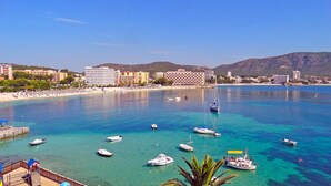 A coastal town with a beach, boats, and buildings. - Hotel Gabarda (Calvia)
