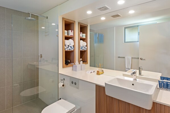 A modern bathroom with a glass shower enclosure, a double sink vanity, and a mirrored cabinet with toiletries. - Discovery Parks - Barossa Valley (Tanunda)