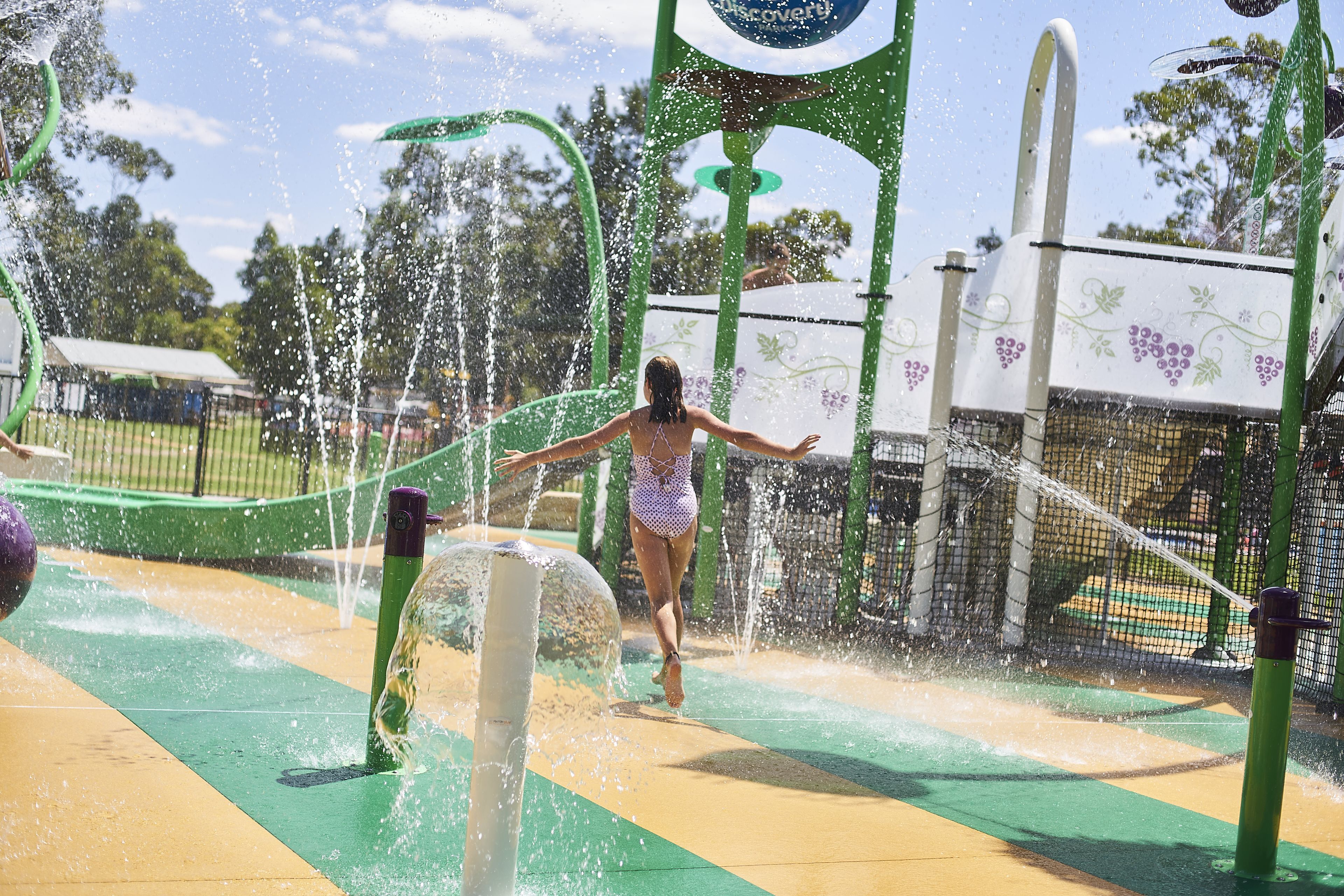A water play area with multiple water jets and a netted enclosure.
