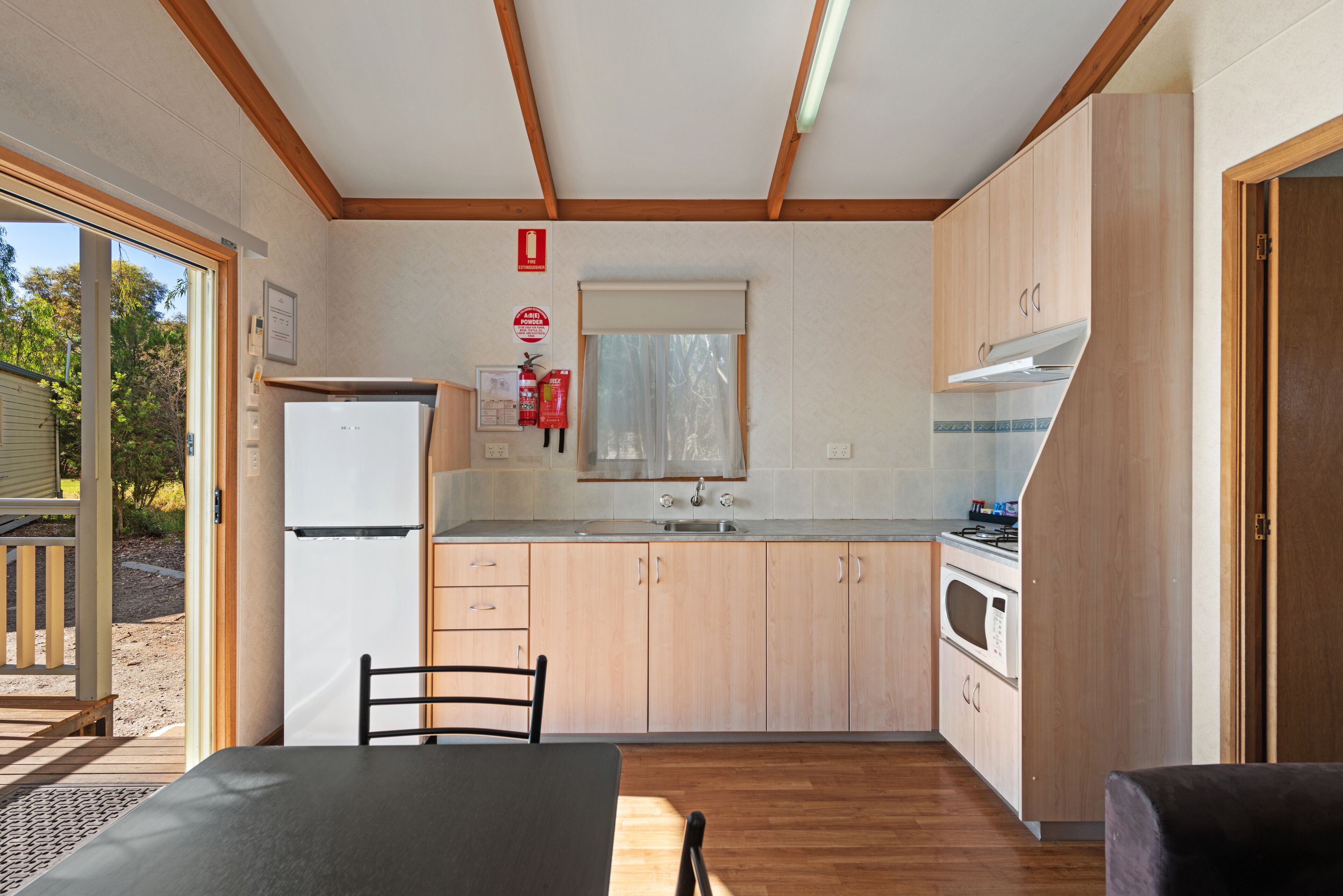 Una cocina compacta con armarios de madera, estufa integrada y refrigerador.